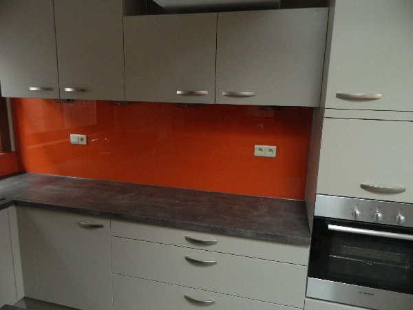 Pose d'une crédence laquée orange dans une cuisine
